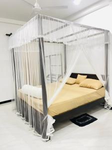 a bed with a canopy in a room at Peacock Villa in Welihinda
