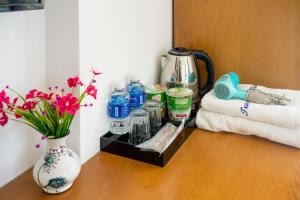 a table with a vase of flowers and a coffee maker at Trang Ngan Hotel by THG in Danang