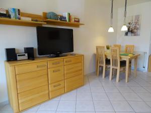 a living room with a television and a table with chairs at Nachtigall 2 in Grönwohldshorst