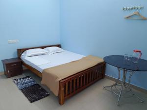 a bedroom with a bed and a table with glasses on it at Travelmate Vagamon in Vagamon