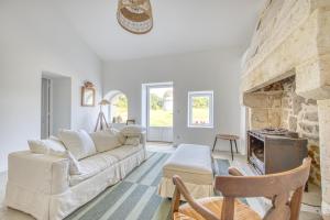 Una sala de estar con un sofá y una chimenea. en Gite De Charme - Daignac, en Daignac