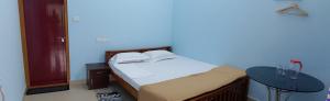 a bedroom with a bed and a table at Travelmate Vagamon in Vagamon