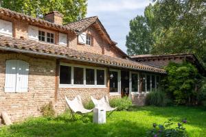 two chairs in the yard of a brick house at Moulin de Cazaux-Savès in Cazaux-Savès