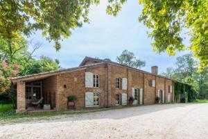 an old brick building on a road at Moulin de Cazaux-Savès in Cazaux-Savès +25 photos