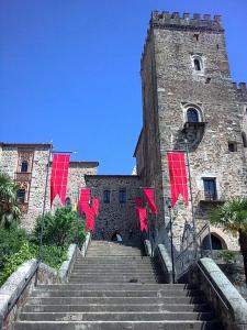 a stone building with red flags on the stairs at Hospederia del Real Monasterio in Guadalupe