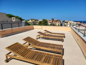 tre panche di legno appoggiate su un tetto di Le Case di Sole Appartamento Mondello a Mondello