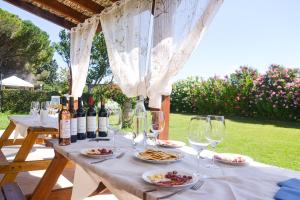 a table with wine glasses and plates of food at Agriturismo La Rondine in Bolgheri
