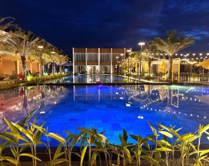 a large pool with blue water at night at Sens Club in Thốt Nốt