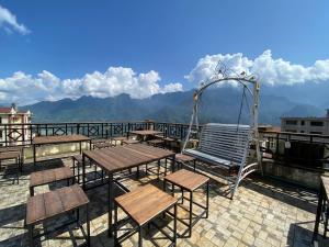 a patio with tables and chairs and a swing at D Home Sapa in Sapa