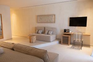 a living room with a couch and a flat screen tv at Aerostay Mykonos in Mikonos