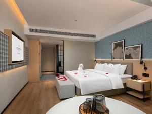 Postel nebo postele na pokoji v ubytování Country Inn & Suite by Radisson, Guangzhou Railway Station Xiaobei