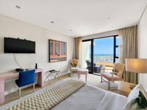 a bedroom with a bed and a desk and a television at Blue Emerald Villa in Cape Town