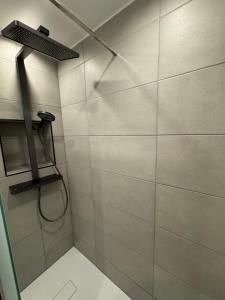 a bathroom with a shower with a shower head at Strandjuwel in der Seehütte Cuxhaven Duhnen- Exclusive Ferienwohnung am Strand mit Meerblick in Cuxhaven