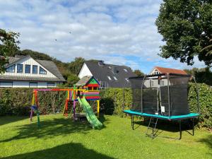 a yard with a playground with a slide and a swing set at Erlebnisurlaub Laboe in Laboe