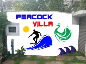 a sign for a surfer on a wave at Peacock Villa in Welihinda