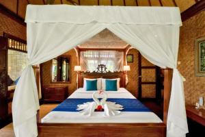 a bedroom with a bed with two swans on it at Isvara 1 BR Junior Suite ZN235 in Ubud