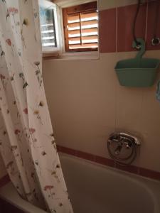 a bathroom with a tub and a shower curtain with birds on it at Apartman Lara in Brodarica +22 photos