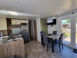 a kitchen and dining room with a table and chairs at Chalet ZilverZand Renesse in Renesse