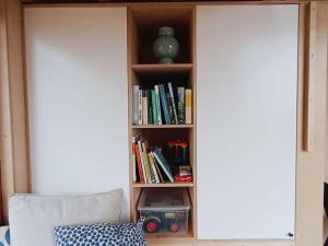 a book shelf with books and a vase on it at Tiny house v ohradě in Čížkov