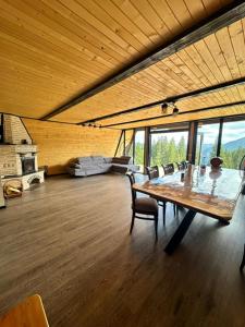 a large room with a large wooden table and chairs at Cabana Piatra Codrilor in Sunători
