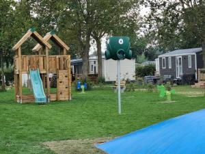 a playground with a wooden play set in a yard at Chalet ZilverZand Renesse in Renesse