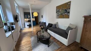 una sala de estar con un sofá y una mesa en Cosy & central flat near Düsseldorf center, en Düsseldorf