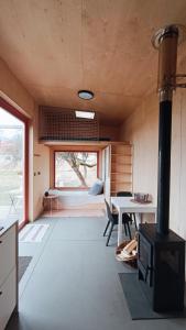 a room with a stove and a table and a bedroom at Tiny house v ohradě in Čížkov
