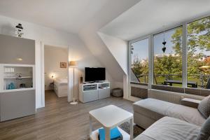 Una sala de estar con un sofá y un televisor. en Wohnanlage Am Mühlenteich, en Timmendorfer Strand