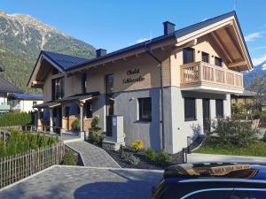 une maison avec une voiture garée devant dans l'établissement Chalet Schlossalm bis 9 Personen, à Bad Hofgastein