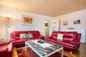 a living room with red couches and a table at Prerow Am Deich - Fewo 3 in Prerow