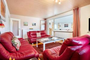 a living room with red leather furniture and a table at Prerow Am Deich - Fewo 3 in Prerow