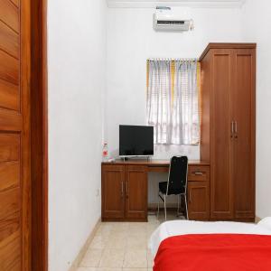 a bedroom with a desk with a computer on it at RedDoorz near Trans Studio Mall Cibubur in Depok +29 photos