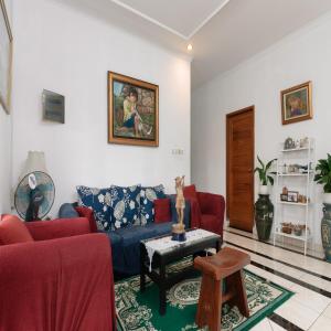 a living room with a blue couch and red chairs at RedDoorz near Trans Studio Mall Cibubur in Depok