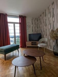 een woonkamer met 2 tafels en een tv bij Sylonie in Châteauroux