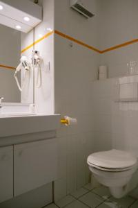 une salle de bain blanche avec toilettes et lavabo dans l'établissement Club Vacances Bleues Les Horizons du Lac (anciennement Serre-du-Villard), à Chorges