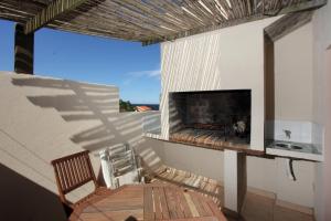 a patio with a fireplace and a table and a chair at Complejo Aguazul in La Pedrera