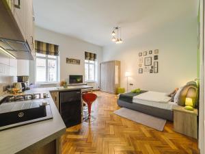 a kitchen and living room with a bed in a room at City Spirit Studio - Piața Mare & Bălcescu View in Sibiu