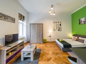 a living room with a bed and a green wall at City Spirit Studio - Piața Mare & Bălcescu View in Sibiu