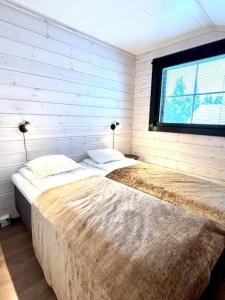 2 camas en un dormitorio con ventana en Sointuilevi 1B by Aavalevi Holidays, en Levi
