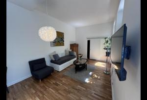 una sala de estar con un sofá y una silla en Cosy & central flat near Düsseldorf center, en Düsseldorf