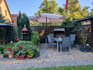 a patio with an umbrella and chairs and plants at Ferienwohnung Suchomski in Baabe