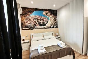 a bedroom with a bed with a painting on the wall at Antoinette Maison in Cefalù