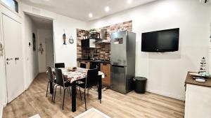 a kitchen and dining room with a table and a television at Antoinette Maison in Cefalù