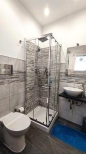 a bathroom with a shower and a toilet and a sink at Antoinette Maison in Cefalù