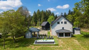 a large white house with a swimming pool in the yard at Plitvice house Angelina in Saborsko