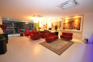 - un salon avec des chaises rouges et une salle d'attente dans l'établissement Parati Palace Hotel, à Santo Antônio de Jesus
