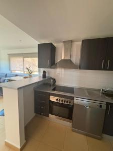 a kitchen with black cabinets and a stove top oven at Casa Golf Mar Menor in Los Martínez