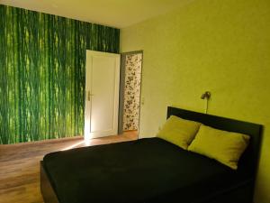 a bedroom with a bed with a green wall at Schöne Eigentumswohnung Saarlouis in Saarlouis