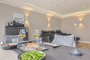Un comedor con una mesa con copas de vino y verduras. en Seewind 2, en Heiligenhafen
