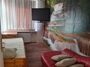 a room with a couch and a tv on a wall at Schöne Eigentumswohnung Saarlouis in Saarlouis